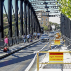 Vallas y balizas impiden el paso en una de las aceras del Puente Colgante, ayer, durante el inicio de las obras de reparación.-J.M. LOSTAU