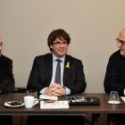 Puigdemont franqueado por su ex consejeros Lluis Puig y Eduard Pujol-JOHN THYS (AFP)