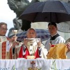 El cardenal arzobispo de Valladolid, Ricardo Blázquez, consagra el Pan y el Vino bajo un paraguas ayer, en la misa del Corpus-J. M. LOSTAU