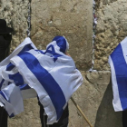 Jóvenes israelís se cubren con la bandera de Israel junto a un untraortodoxo frente al Muro de las Lamentaciones. /-AP / DAN BALILTY