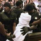 Habré, completamente tapado con una vestimenta blanca, rodeado de policías en el tribunal, en Dakar, este lunes.-Foto: AFP / SEILLOU