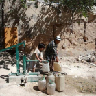 Un chico llena garrafas de agua en Damasco, Siria.-BASSAM KHABIEH