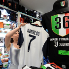 Una vendedora coloca una camiseta de Cristiano con el 7 de la Juventus.-REUTERS / MASSIMO PINCA