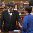 El presidente de la Generalitat, Carles Puigdemont, y la diputada de la CUP Mireia Boya, en el Parlament.-ALBERT BERTRAN