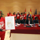 Una de las portavoces de los afectados, Esther Mate, sostiene el documento suscrito por PSOE, Podemos, Izquierda Unida, Ciudadanos y UPL en apoyo de los afectados por la Hepatitis C-Ical