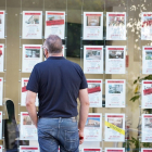 Un hombre observa carteles en el escaparate de una inmobiliaria. ICAL