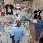 Visitantes de la Feria de Mitomanías y Aficiones buscan ediciones singulares en un expositor de cómics.-ICAL