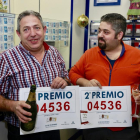 El propietario del despacho de lotería y cafetería Café de la Suerte, Manuel Martínez (I), vendedor de cinco décimos agraciados con el segundo premio de la Lotería de Navidad, junto a uno de los afortunados-Carlos S. Campillo / ICAL