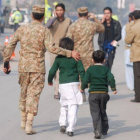 Un soldado paquistaní escolta a dos niños rescatados de la escuela que ha sufrido el ataque en Peshawar.-Foto: REUTERS / KHURAM PARVEZ