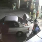 Imagen de la grabación de una cámara de seguridad en que se ve como unos ladrones intentan llevarse un gran botín de tabaco en un saco tan grande que no les cabe en el coche.-