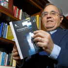 El autor, Arturo Rodríguez–Monsalve, posa con su segundo libro en la biblioteca de su domicilio.-J. M. LOSTAU