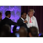 Donald Trump con una túnica de oración durante la visita a una iglesia negra en Detroit.-EVAN VUCCI / AP