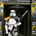 Un Storm Trooper (soldado de la fuerza oscura de 'Star Wars') frente a un cartel para 'reclutar' frikis.-
