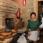 Alberto Sánchez, propietario del restaurante La Encina,de Palencia, saca del horno unos cuartos de lechazo, junto a su madre Ciri González.-MANUEL BRÁGIMO