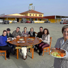 Mari Carmen Amez, en primer término, con un chuletón de búfalo, y su familia detrás. De i. a d.: Miriam, Carlos, Eduardo, Camino, Laura, Juan y Ana.-ARGICOMUNICACIÓN