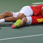 Rafa Nadal y Marc López se abrazan en el suelo tras clasificarse para la final olímpica.-AFP / LUIS ACOSTA