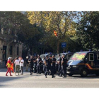 Varias personas saludan a unos agentes de la Policía Nacional, en Barcelona.-JÚLIA REGUÉ