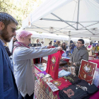 Dos clientes del mercado de la calle Ferrari interactuan con el artesano.-JOSE C. CASTILLO (PHOTOGENIC)