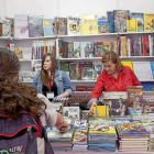 Dos jóvenes observan uno de los expositores de la Feria del Libro en la Cúpula del Milenio-Pablo Requejo