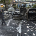 Un hombre camina junto a una hilera de coches carbonizados tras unos disturbios en mayo del 2013, en un suburbio de Estocolmo.-Foto: EFE / FREDRIK SANDBERG