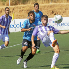 Dani Vega intenta bajar el balón ante dos jugadores del Boiro-J. M. LOSTAU