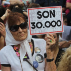 Una mujer sostiene un cartel en referencia a los 30.000 desaparecidos mientras escucha el veredicto por los crímenes cometidos en la ESMA, en Buenos Aires, el 29 de noviembre.-/ EFE / CARLOTA CIUDAD
