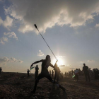 Un manifestante lanza una piedra con su honda durante unos disturbios en la frontera con Israel tras los rezos del Viernes, en Gaza, Cisjordania.-EFE