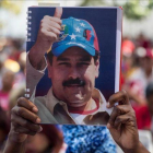 Una mujer seguidora del oficialismo venezolano sostiene una fotografía del presidente Nicolás Maduro el pasado sábado.-EFE / MIGUEL GURIERREZ