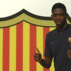 Dembelé posa ante el escudo del Barça en las oficinas del Camp Nou.-AFP / LLUÍS GENÉ
