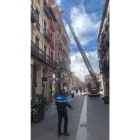 Bomberos revisan una chapa suelta en un edificio de la calle Lencería.- TWITTER POLICÍA VALLADOLID