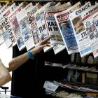 Una mujer mira con curiosidad y cierto temor la oferta informativa de la prensa griega.-Foto:   AP / PETROS KRADJIAS