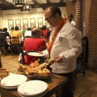 José María Ruiz trincha un cochinillo con un plato en una de las salas de su restaurante segoviano.-L.P.