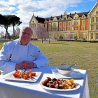 l cocinero Alberto Suárez con el cocido del restaurante del Gran Hotel Palacio de las Salinas sobre la mesa, ante la fachada del histórico balneario-AGROCOMUNICACIÓN