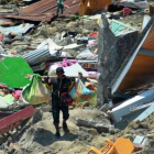 Un hombre carga objetos personales entre los escombros de un edificio derrumbado por el terremoto, en la ciudad indonesia de Palu.-RIFKI (AP)