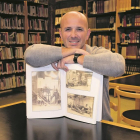 Enrique Bravo con un libro de fotografías antiguas que muestran el interior del obrador de Fontaneda en una de las salas de la biblioteca de Aguilar de Campoo.-E.M.