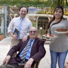Félix, con su novela ‘Desahucio’, junto a su padre (sentado) y su pareja, Kimberly, que atiende el comedor del restaurante.-ARGICOMUNICACIÓN