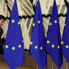 Un funcionario prepara las banderas de la Unión Europea antes del inicio de la cumbre, este domingo en Bruselas.-AFP