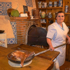 Isabel Alameda, con un cuarto de lechazo asado, uno de los platos más representativos de la casa.-ARGI