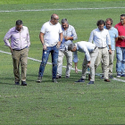 Luis Gil, de LaLiga, agacahado, observa el césped junto a representes del Real Valladolid y Sport Relva.-J.M. LOSTAU