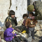 Un militar ruso entrega supuestamente zumo de frutas a niños de Alepo (Siria), en una imagen sin fecha distribuida por el Ministerio de Defensa ruso.-/ AP