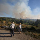 Dos personas observan la cortina de humo que se levantó durante la jornada de ayer.-ICAL