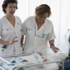 Dos trabajadoras del Sacyl posan con el primer niño nacido en Ávila en 2017.-ICAL