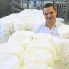 Miguel Pérez  asoma con un queso fresco entre los moldes y telas bancas que utiliza en la elaboración. Abajo, algunos de los quesos que elabora-M. T.