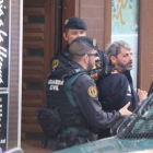 Dos agentes de la Guardia Civil se llevan un detenido en Sabadell en el marco de la operación que ha acabado con nueve miembros de CDR arrestados.-MIQUEL CODOLAR