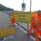 Operarios del servicio de carreteras de la Junta retiran los carteles que cortaban el paso en el puente medieval de Cabezón.-J. M. Lostau