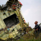 Un investigador inspecciona los restos del avión malasio siniestrado.-MAXIM ZMEYEV (REUTERS)