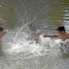Imagen de unos jóvenes refrescándose en la Playa de las Moreras durante la pasada ola de calor.-J.M.LOSTAU