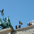 Los ultras de Movimiento Identitario, en lo alto de la Puerta de Brademburgo.-EFE / PAUL ZINKEN