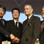 El asesor especial del primer ministro de Japón y el representante de Mitsubishi Motors se estrechan la mano con James Murphy, exprisionero de guerra estadounidense, durante el acto que tuvo lugar el domingo en Los Angeles.-Foto: AP / DAMIAN DOVARGANES