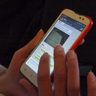 Una joven chatea con su teléfono móvil.-EL MUNDO